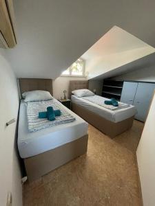 2 camas individuais num quarto com um sótão em Apartmani Rozi em Umag