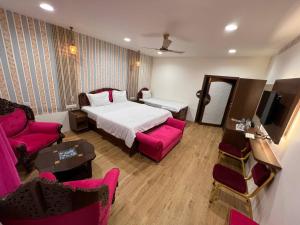 um quarto de hotel com uma cama e mobiliário rosa em hotel babu heritage em Bikaner