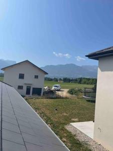 a white house with a car parked in a field at Kazandko : Location meublée Haute-Savoie in Arenthon +22 photos