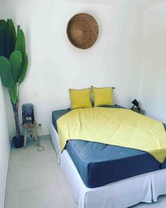 Un dormitorio con una cama con sábanas amarillas y azules y una planta en Kazandko : Location meublée Haute-Savoie en Arenthon