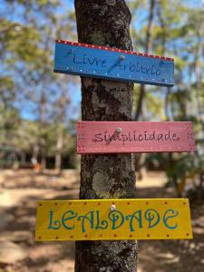 un árbol con signos en su lado en Pousada Aconchego, en Pirenópolis