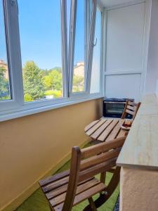 two benches sitting in a room with two windows at Студио апартамент Троян in Troyan