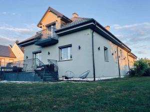 ein weißes Haus mit einem Balkon und einer Liegewiese in der Unterkunft Dream House SmartHome in Warschau