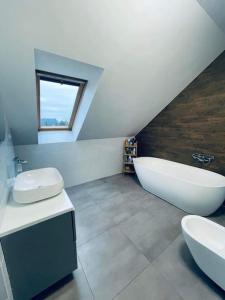 ein Badezimmer mit zwei Waschbecken, einer Badewanne und einem Fenster in der Unterkunft Dream House SmartHome in Warschau