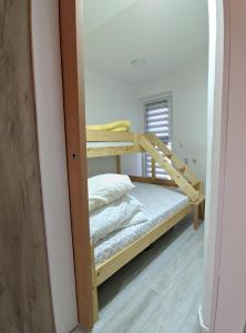 a small bedroom with a bunk bed and a mirror at Enigma Apartmani Divcibare in Divčibare