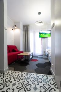 a hotel room with a red couch and a bed at Moon Apartments Gdańsk in Gdańsk