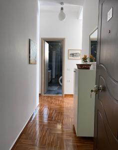 a hallway with a door and a wooden floor at Port Side Sarande in Sarandë