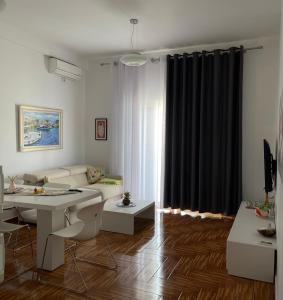 a living room with a couch and a table at Port Side Sarande in Sarandë