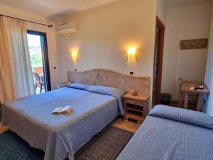 pokój hotelowy z dwoma łóżkami i oknem w obiekcie Hotel Delle Isole w mieście La Maddalena