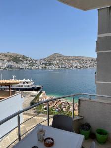 a balcony with a view of the water and a boat at Port Side Sarande in Sarandë