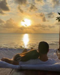 un homme et une femme assis dans un bain à remous pour admirer le coucher du soleil dans l'établissement Natural Garden Hotel, à Jambiani