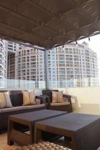 a patio with couches and tables and a large umbrella at Seaview Rooftop in San Stefano in Alexandria