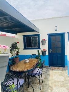 um pátio com uma mesa e cadeiras e uma porta azul em Chez abdelilah em Oualidia