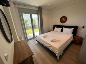 1 dormitorio con 1 cama con 2 toallas en Villas Vento Lefkada, en Agios Nikitas