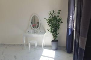 a white table with a mirror and a potted plant at Aida's Home-Shmeisani central location near Abdali in Amman
