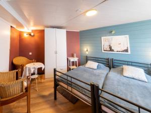 una camera da letto con due letti, un tavolo e una sedia di Charming Cottage Near Lake a Robertville