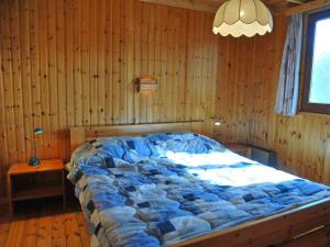 1 dormitorio con 1 cama grande en una pared de madera en Cosy Holiday Home in Noiseux with Large Garden, en Noiseux