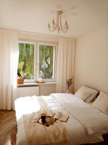 a bedroom with a large white bed with a plate on it at Apartament Home Mi in Nysa