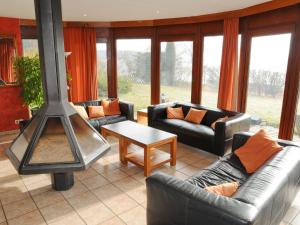 een woonkamer met banken en een houtkachel bij Family home in stunning setting, with outdoor swimming pool and large garden in Somme-Leuze