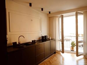 uma cozinha com um lavatório e uma grande janela em Apartament Home Mi em Nysa