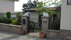 Una cerca con una puerta con estatuas. en Agriturismo Bagarellum, en Montecalvo Versiggia