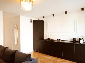 a kitchen with a black counter and a couch at Apartament Home Mi in Nysa