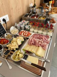 un buffet con queso y otros alimentos en una mesa en B&B Garda Home, en Nago-Torbole