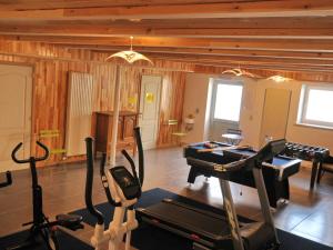 a fitness room with a gym with tread machines at Cozy Holiday Home in Bastogne with Sauna in Bastogne