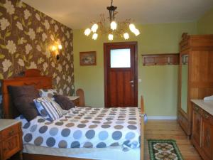 - une chambre avec un lit et un lustre dans l'établissement Cozy Holiday Home in Bastogne with Sauna, à Bastogne