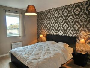 Un dormitorio con una gran cama blanca con una pared estampada en Peaceful Holiday Home in Somme-Leuze with Sauna, en Noiseux