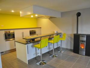 cocina con paredes amarillas y encimera con sillas amarillas en Peaceful Holiday Home in Somme-Leuze with Sauna, en Noiseux