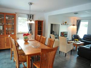 a dining room and living room with a table and chairs at Beautiful Holiday Home in Barvaux-sur-Ourthe with Sauna in Barvaux