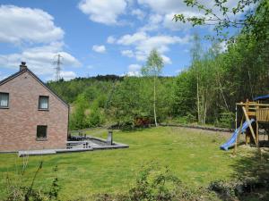 a yard with a house and a playground at Beautiful Holiday Home in Barvaux-sur-Ourthe with Sauna in Barvaux