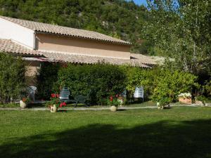 een huis met twee stoelen en bloemen in een tuin bij Lei Canissouns in Castellane