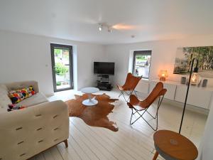 a living room with a couch and a table and chairs at Cosy apartment in the heart of Durbuy in Durbuy
