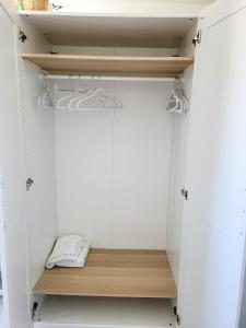un armadio con porte bianche e una mensola in legno di Chambre climatisée lit double - Proche tram & Centre a Montpellier