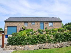 a brick house with blue doors and bushes at Attractive holiday home in Hampteau with garden in Hampteau