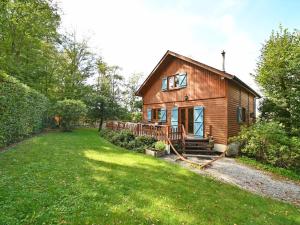 a small wooden house in a field with a yard at Pleasant detached chalet with sauna near Durbuy in Biron