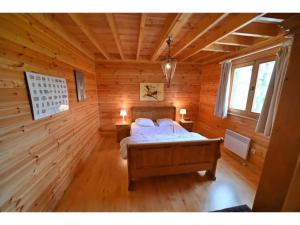 um quarto com uma cama num chalé de madeira em Pleasant detached chalet with sauna near Durbuy em Biron