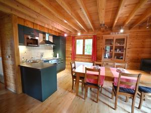 uma cozinha e sala de jantar com mesa e cadeiras em Pleasant detached chalet with sauna near Durbuy em Biron