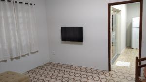 ein Wohnzimmer mit einem Flachbild-TV an der Wand in der Unterkunft Confortável e espaçosa in Bebedouro