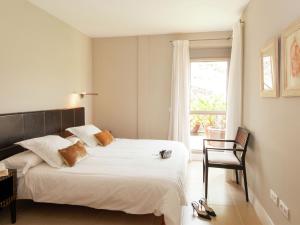 een slaapkamer met een bed, een stoel en een raam bij Belvilla by OYO Vibrant Villa with Swimming Pool in Salobre +16 foto's