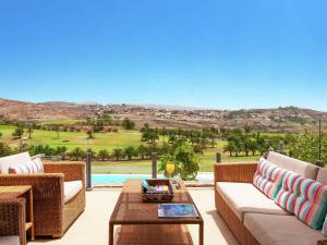 een terras met rieten meubels en uitzicht op de woestijn bij Belvilla by OYO Vibrant Villa with Swimming Pool in Salobre