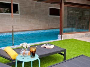 een tafel met een drankje erop naast een zwembad bij Magnificent Villa with Swimming Pool on an Exclusive Island in Ingenio