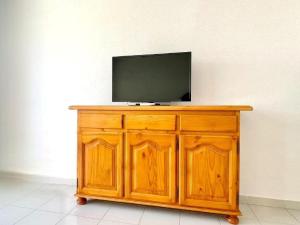 a television sitting on top of a wooden cabinet at Beachfront apartment in Roquetas de Mar with communal pool in Roquetas de Mar