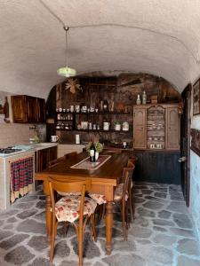 cocina con mesa de madera y sillas en Baita Borgo Incantato, en Morbegno