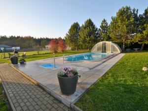 a backyard with a swimming pool and a greenhouse at Spacious Villa in Nemojov Bohemian with Swimming Pool in Nemojov