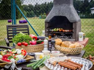 een tafel met manden groenten en een grill bij Spacious Villa in Nemojov Bohemian with Swimming Pool in Nemojov