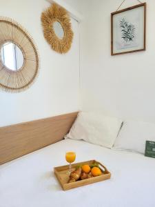 un vassoio di frutta e un bicchiere su un letto di Chambre climatisée lit double - Proche tram & Centre a Montpellier
