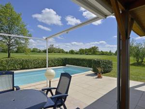 eine Terrasse mit einem Pool mit Stühlen und einem Tisch in der Unterkunft Tasteful villa with Wi-Fi, located in natural surroundings in Vasles